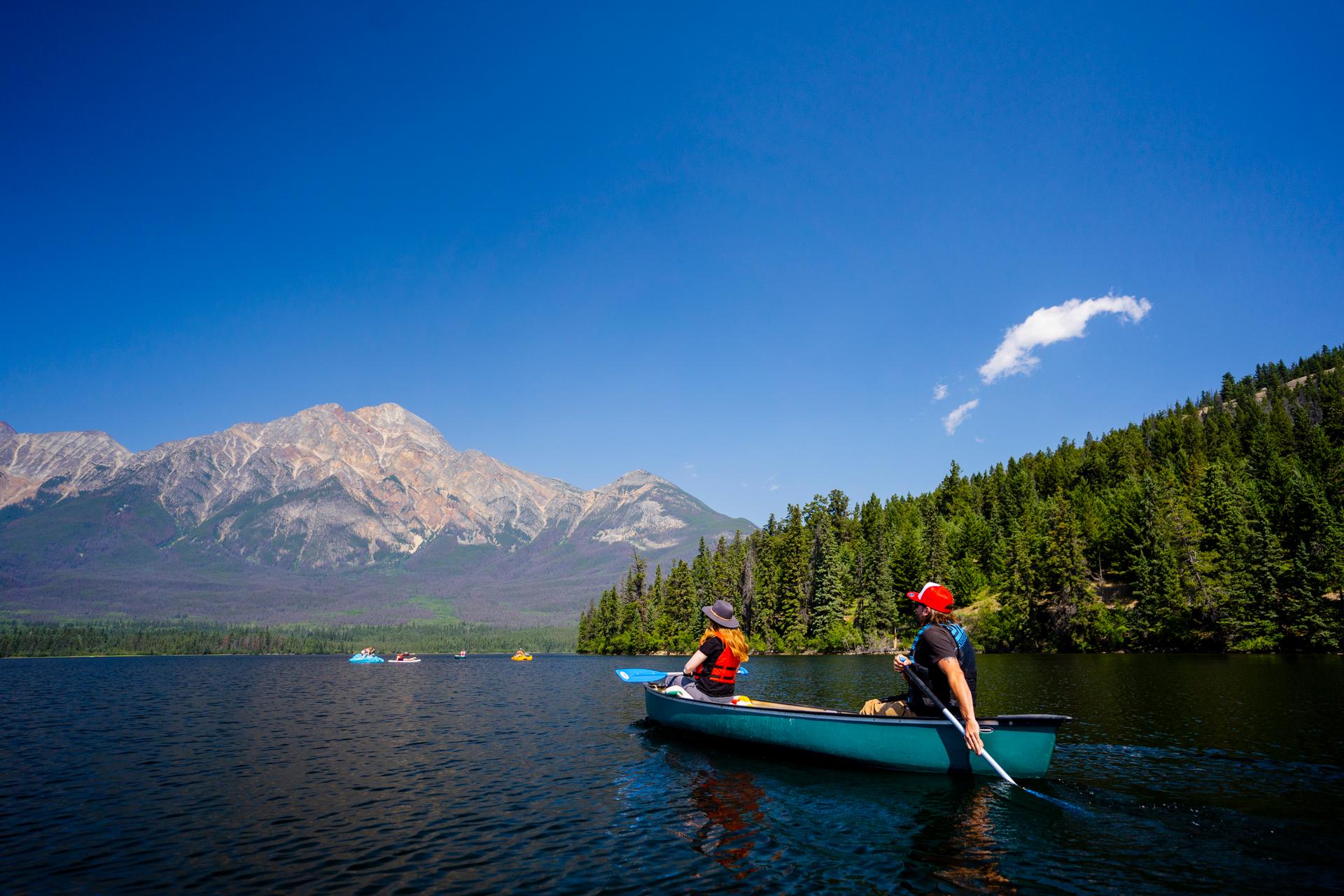 A couple on a kayak on a lake looking at the mountain