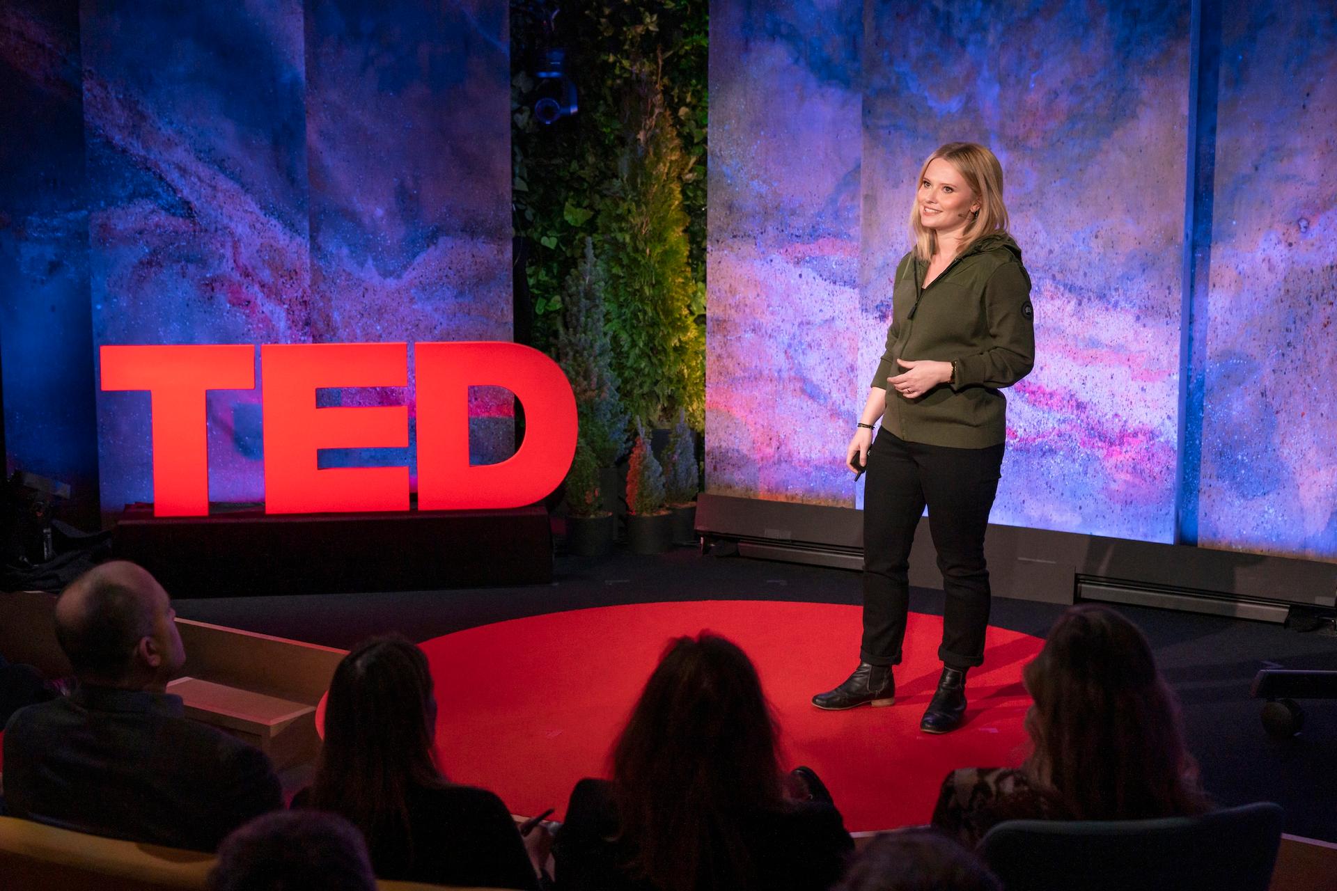 Alysa McCall gives a TED talk on the TED stage.