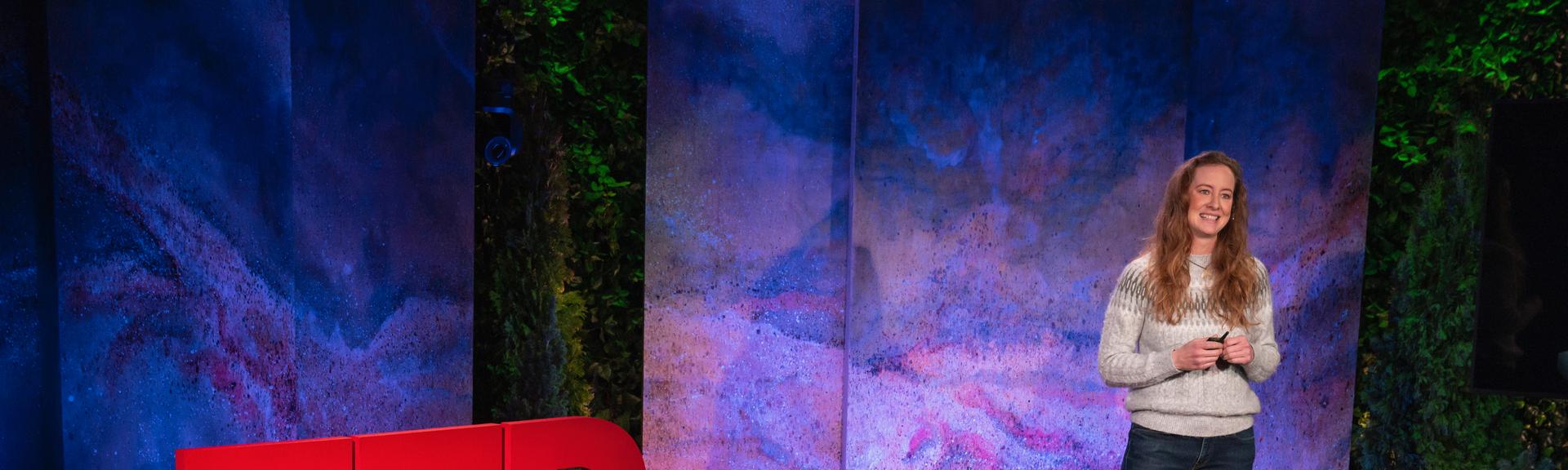 Lori McCarthy gives a TED talk on the TED stage.