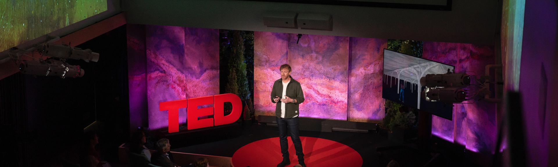 Michael Green gives a TED talk on the TED stage.