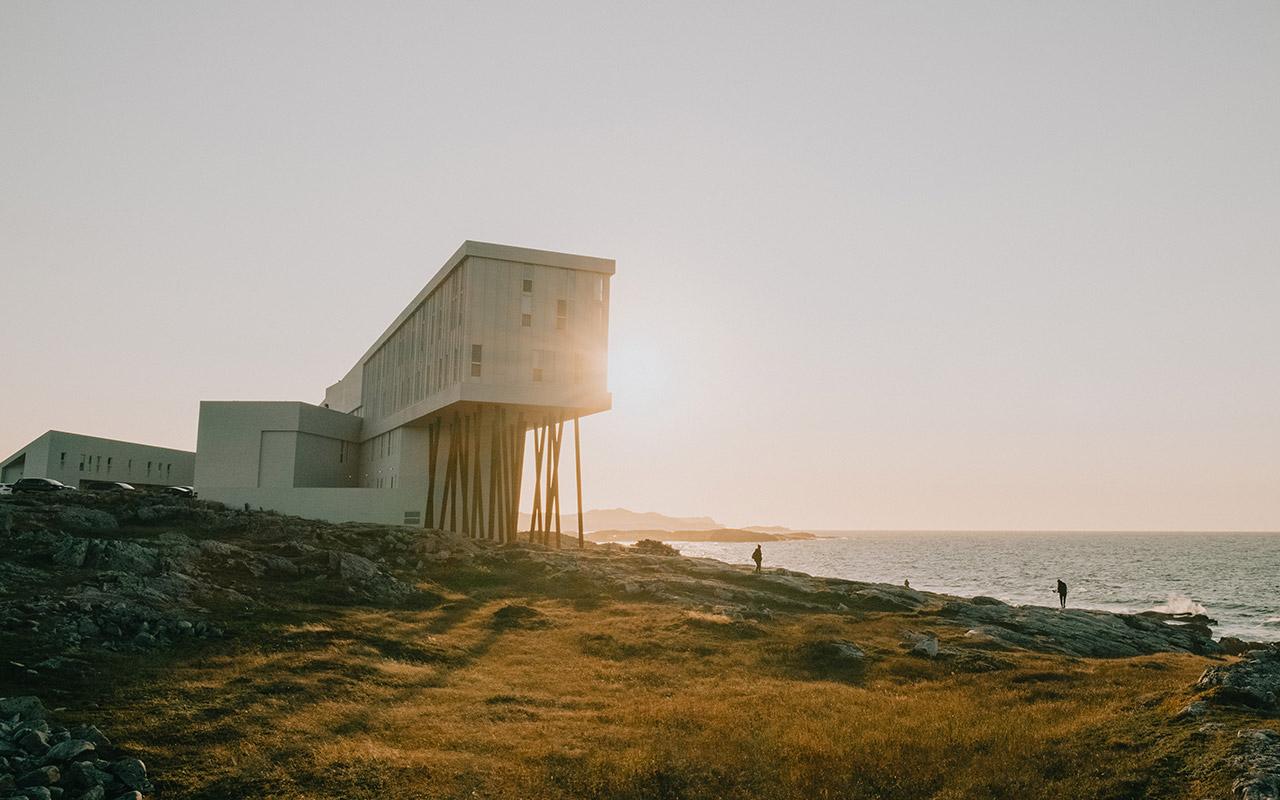 Modern building on stilts overlooking the ocean at sunset on Fogo Island, Newfoundland and Labrador.